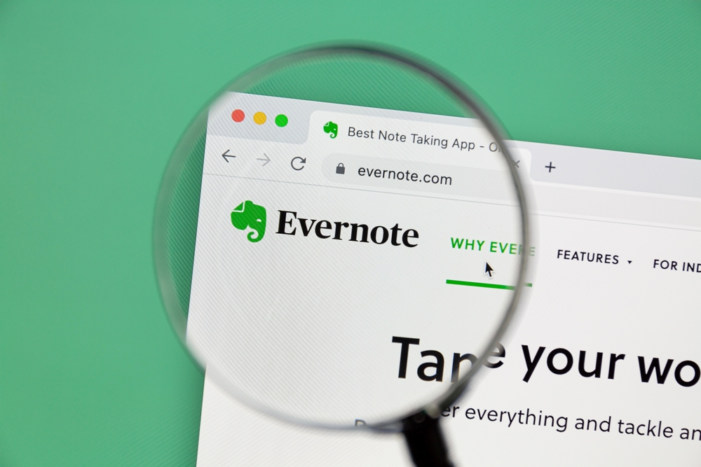Imagem de uma tela de computador com o site do Evernote aberto, visualizado através de uma lupa, com foco na página inicial do app de notas.