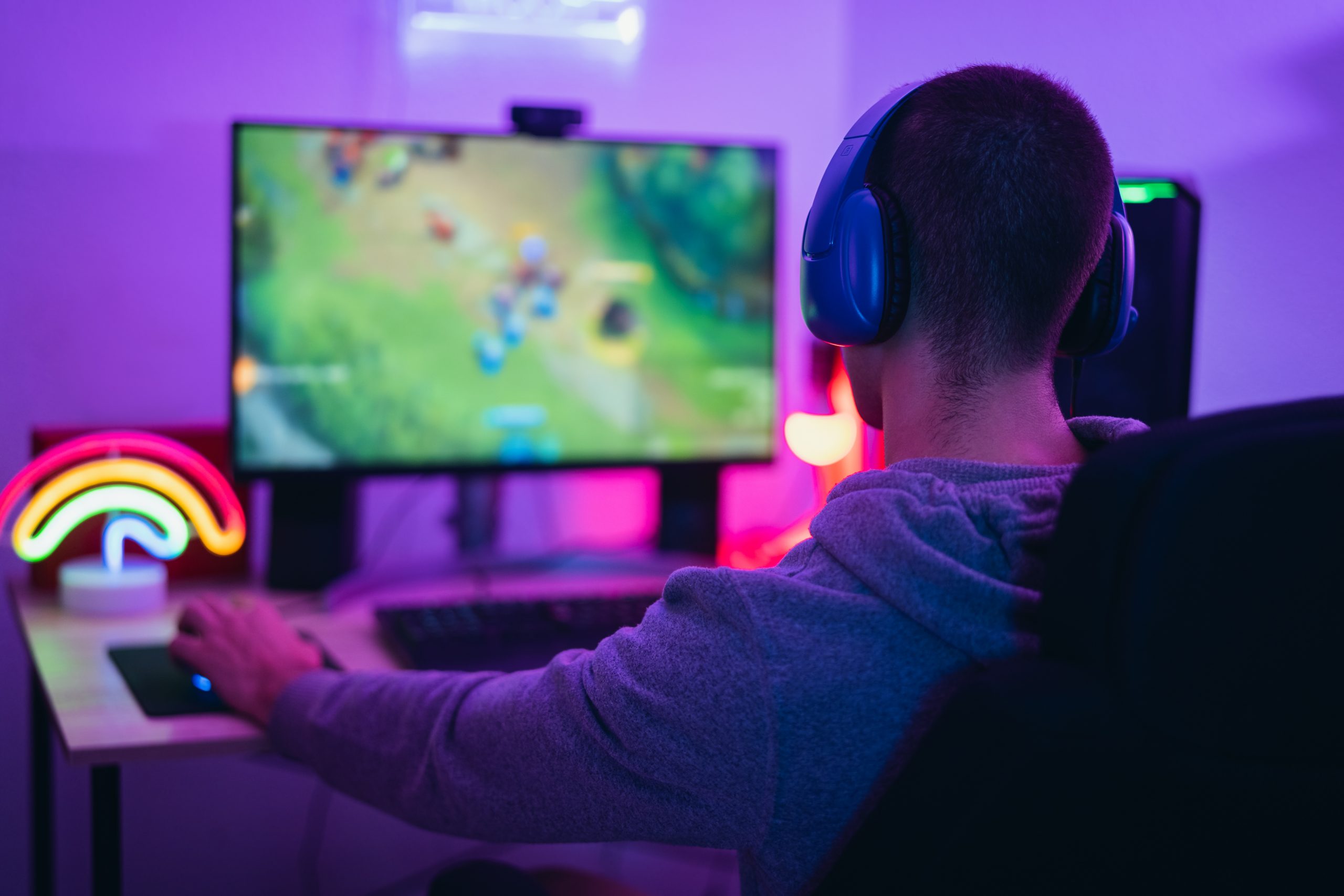 homem caucasiano sentado na cadeira, jogando e transmitindo ao vivo em plataformas de streaming de jogos como a Twitch