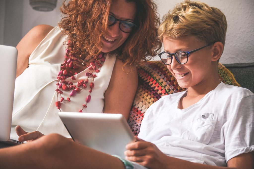 fotografia de mãe e filho vendo histórias educativas online como opção de programação dia das crianças
